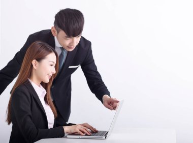 İş ekibi dizüstü bilgisayar kullanıyor ve ofiste birlikte çalışıyorlar.