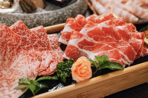 高档鲜切片猪肉 带有高大理石质感的圆形木制盘子 用于火锅和沙布 — 图库照片