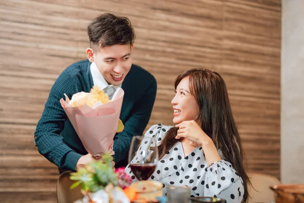 Young man greeting his girlfriend on Valentine\'s Day at restaurant