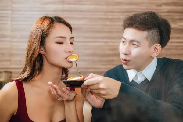 年轻的亚洲男人在餐馆里用美味的食物喂快乐的女朋友 — 图库照片