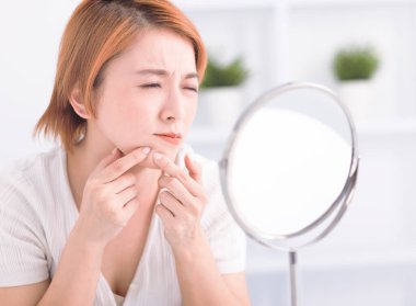  Genç bir kadın yüzünden sivilce çıkarmak için sivilce çıkartıyor..