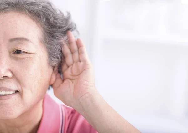 Closeup senior woman hearing loss , Hard of hearing