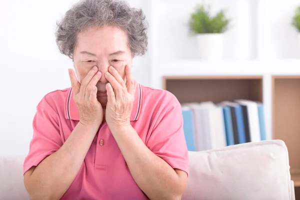 Frustrated stressed senior older grandmother suffering from blurred eyesight, eyes strain pain ache.