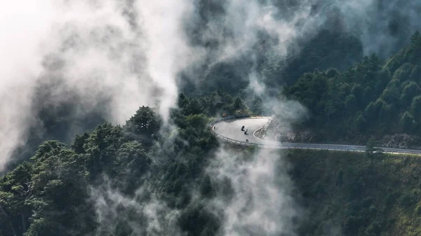 山上のオートバイライダーとカービートロードの空中ビュー ストック画像