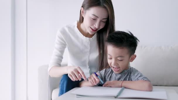 Young Mother Checking Homework Helping Child Study Home — Stockvideo