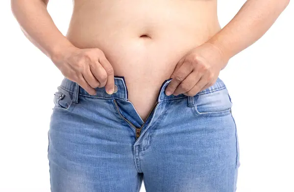 ジーンズを着用するしようとしている脂肪の女性 ロイヤリティフリーのストック画像