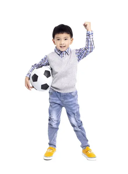 ホワイトバックで孤立したサッカーを持つ幸せなアジアの少年 ストックフォト