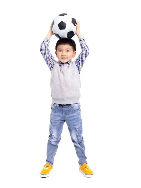 快乐的亚洲男孩 与足球隔离在白人背景下 图库图片