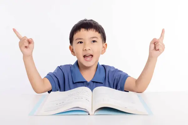 Emocionado Asiático Niño Escolar Estudiar Casa Mano Apuntando Hacia Arriba Imagen de archivo
