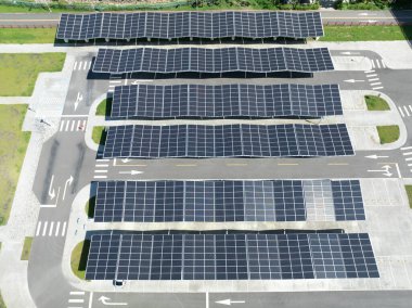 Aerial view above innovative solar panels located on a car parking lot rooftops clipart