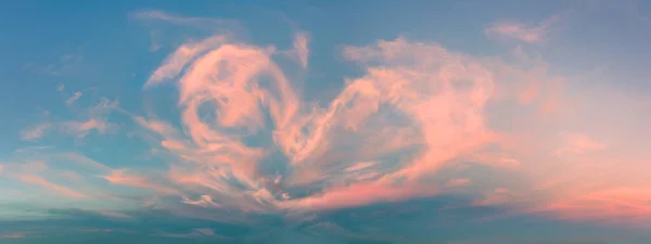 Magic real heart made from clouds in the sunset sky. Pink light heart shaped clouds. Love. Panoramic sky for Valentine\'s Day, Wedding, Mother\'s Day. Holidays of love and tenderness