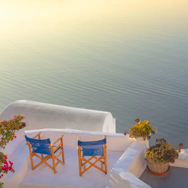 ギリシャのサントリーニ島 海を見下ろすテラスで2つの椅子とサントリーニ島の夕日 ロマンチックな時間だ ギリシャ サントリーニ島の休日 — ストック写真