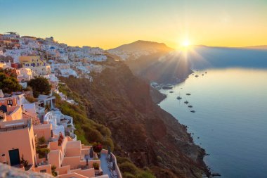 Santorini, Yunanistan. Meşhur Santorini adasında gün doğumu, Oia şehrinin manzarası. Güneş doğar ve Santorini 'nin geleneksel Yunan mimarisini aydınlatır. Romantik zamanlar. Yunanistan 'da tatiller, Santorini.