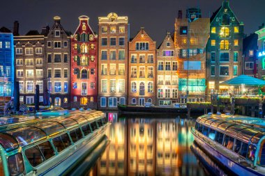 Amsterdam 'ın ünlü eski evleri. Evler suda duruyor ve güzel bir yansımaları var. Damrak 'ın turistik bölgesi. Bu evler dünyanın her yerinde ünlüdür. Amsterdam, Hollanda, Avrupa
