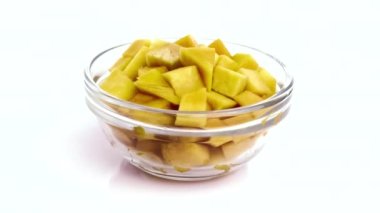 Beyaz arka planda izole edilmiş bir kasede kesilmiş mango.