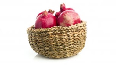 Beyaz arkaplanda izole edilmiş sepetteki nar.