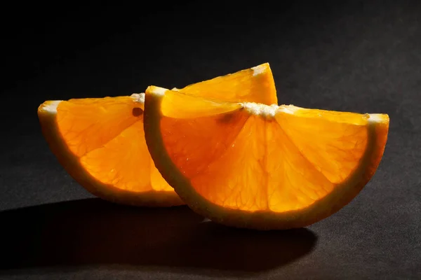 sliced orange fruit on black background