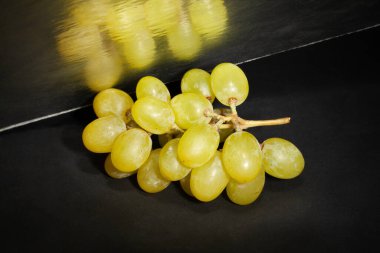 Siyah arkaplanda aynalı beyaz üzüm