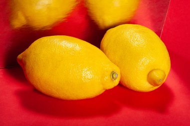 Kırmızı arka planda aynalı limon