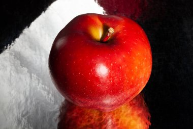 Siyah yansıtıcı arka planda kırmızı lezzetli elma