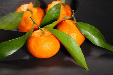 Siyah arkaplanda aynalı mandalina