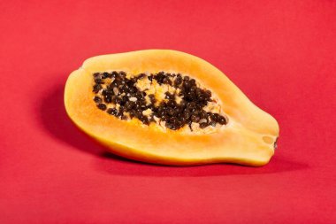 Kırmızı arka planda dilimlenmiş papaya