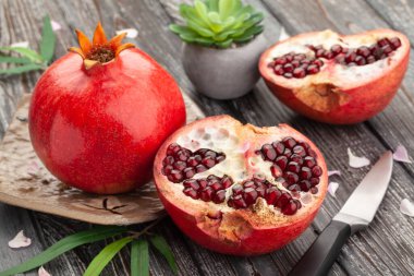 Tahta zemin üzerinde dilimlenmiş nar.