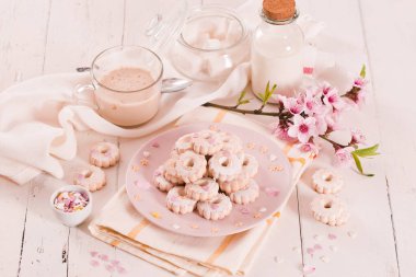 Canestrelli bisküvileri. Beyaz tabakta krema şekeri.. 