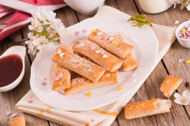 Beyaz tabakta şekerli puf böreği..