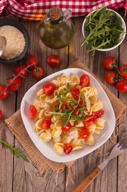 Orecchiette pasta with arugula and tomato.