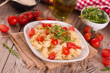 Orecchiette pasta with arugula and tomato.
