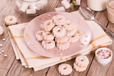 Canestrelli biscuits with icing sugar on pink dish. 