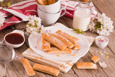 Beyaz tabakta şekerli puf böreği..