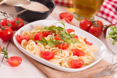 Orecchiette pasta with arugula and tomato.