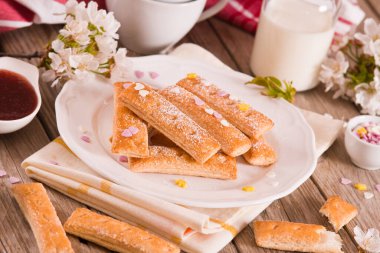 Beyaz tabakta şekerli puf böreği..