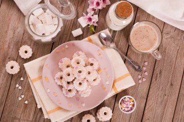 Canestrelli biscuits with icing sugar on pink dish. 