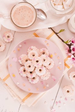 Canestrelli biscuits with icing sugar on pink dish. 