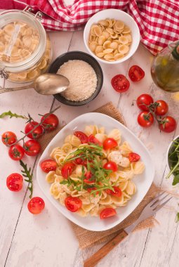 Orecchiette pasta with arugula and tomato.