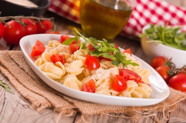 Orecchiette pasta with arugula and tomato.