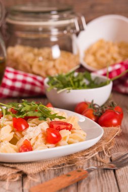 Orecchiette pasta with arugula and tomato.