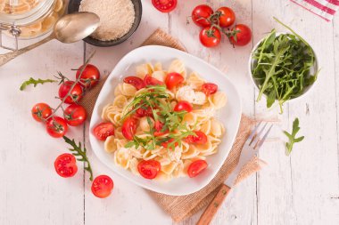Orecchiette pasta with arugula and tomato.