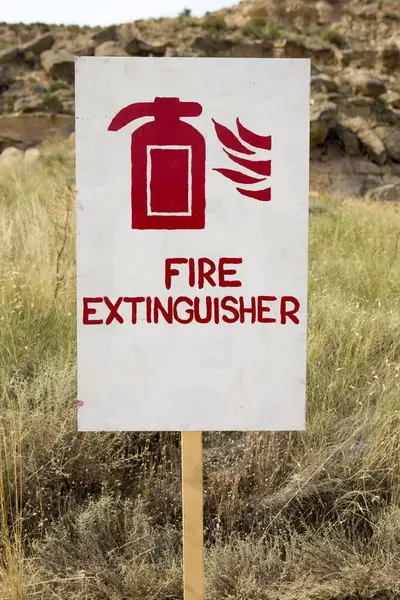 Red Fire sign extinguisher with nature in the background