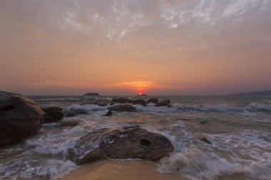 Gün batımında dalgalar ve turuncu gökyüzü Kamboçya 'da