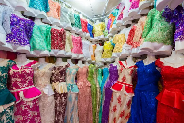 Mankenler bir giyim mağazasında canlı bir dantel elbise koleksiyonu sergiliyor..