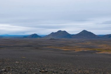 Kıyı kum tepeleri, dağlarla ve yel değirmenleriyle desteklenen denizle buluşur. Costa Brava, İspanya