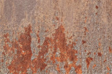 Texture of a metallic rusty wall.Cracked peeling old paint on a metallic rusty surface