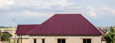 Metal bir profilden gökyüzüne karşı evin çatısını.