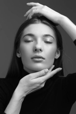 Uzun saçlı, siyah beyaz tek renkli güzel bir kadının stüdyo portresi.