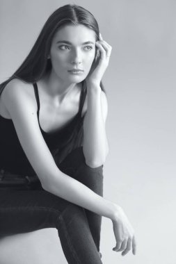 Uzun saçlı, siyah beyaz tek renkli güzel bir kadının stüdyo portresi.