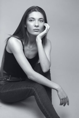 Uzun saçlı, siyah beyaz tek renkli güzel bir kadının stüdyo portresi.